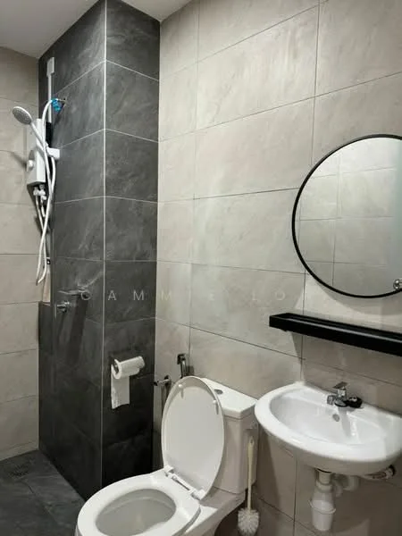 Bathroom features: walk-in shower with glass enclosure, rain shower head, chrome handheld shower, white toilet, round mirror, black countertop, white pedestal sink, grey tiled walls, dark grey accent wall, towel holder, toilet paper holder; style: modern.