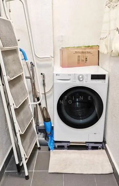 Laundry features: front-load washing machine, white appliance, grey tiled flooring, folding drying rack, cleaning broom, mop, storage box, wall-mounted shelf.