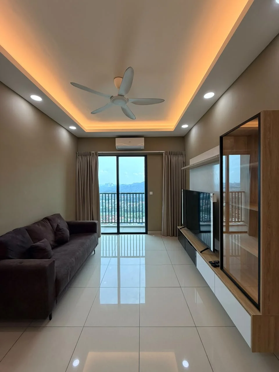 Living features: 3-seater fabric sofa in dark brown, floor-to-ceiling sliding glass door, mountain view, white wall with brown accent wall, recessed LED downlights, 5-blade ceiling fan with light, glossy ceramic tile flooring, TV console with storage, wall-mounted TV, curtains, air conditioning unit; style: modern; view: mountain.