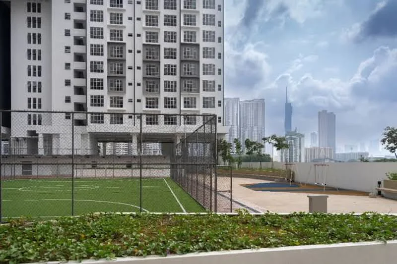 Exterior type: high-rise condominium; features: green soccer field, basketball court, fenced perimeter, landscaped garden area, multiple storey building, city skyline in background, modern architectural design, large windows on facade; style: modern.