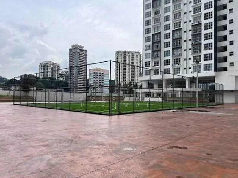 Exterior features: fenced multi-sport court, artificial grass surface, surrounding high-rise buildings, concrete flooring, open space, urban landscape, cloudy sky; style: modern.