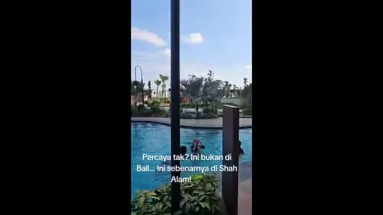 Exterior type: swimming pool deck; features: infinity pool, pool deck with loungers, tropical landscaping, palm trees, manicured lawn, surrounded by greenery; style: tropical-modern.