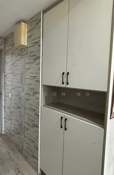 Room features: white cabinetry with black handles, textured stone-patterned wall, light wood flooring, wall-mounted light fixture; style: modern.