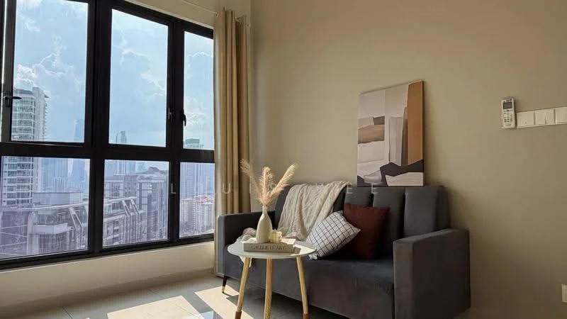 Living features: grey fabric sofa, decorative throw pillows, small round coffee table, framed artwork on wall, floor-to-ceiling windows, sheer curtains, light beige painted walls, tile flooring, city skyline view; style: modern; view: city.