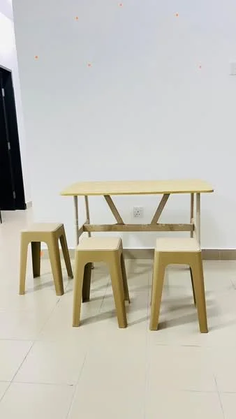 Room features: light beige walls, light-colored tiled flooring, small rectangular table, three plastic stools, minimalist design, no visible decor, neutral color palette; style: minimalist.