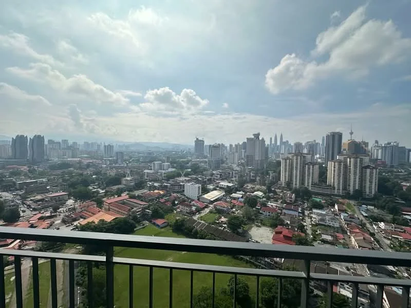 Exterior type: high-rise condominium; features: city skyline view, surrounded by urban landscape, green park area visible, high-rise buildings in the background, mixed residential and commercial structures, clear blue sky with scattered clouds; style: modern.