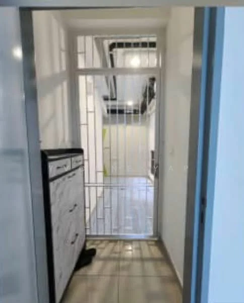 Room features: white painted walls, grey tiled flooring, metal security grille door, built-in cabinet with drawers, open space leading to another area; style: modern.