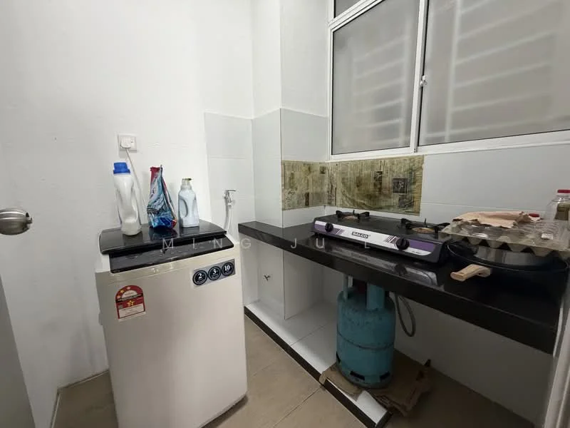 Laundry features: top-load washing machine, black countertop, gas stove with two burners, blue gas cylinder, white tiled walls, grey tiled flooring, window for natural light, bottle of detergent, bottle of fabric softener.