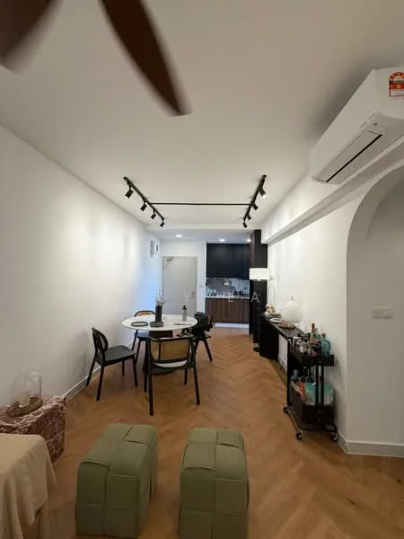 Living features: light wood herringbone flooring, white painted walls, track lighting, wall-mounted air conditioning unit, round dining table, 4 black dining chairs, console table against the wall, 2 green ottomans, open kitchen area visible in the background; style: modern.