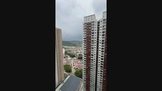 Exterior type: high-rise condominium; features: glass curtain wall, red brick facade, surrounded by mature greenery, city skyline view, adjacent to residential area; style: modern.