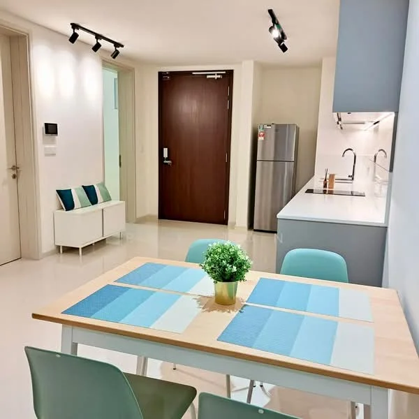 Dining features: dining table with light wood surface, 4 green dining chairs, decorative plant in a gold pot, blue and white placemats, recessed ceiling lights, white walls, glossy tile flooring, open layout to kitchen, fridge visible in background, kitchen countertop with sink visible; style: modern. Kitchen features: white cabinetry, stainless-steel fridge, kitchen sink, wall-mounted faucet, countertop with minimalist design, recessed lighting; style: modern.