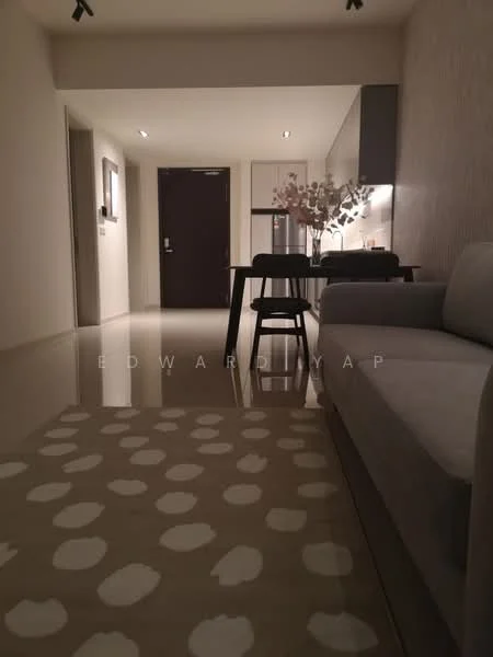 Living features: grey fabric sofa, coffee table, area rug with polka dot pattern, recessed downlights, open-plan layout, polished floor tiles, wall-mounted TV, dining table with chairs, kitchen cabinetry visible in background, neutral wall color; style: modern. Room features: doorway leading to hallway, kitchen area visible, light fixtures.