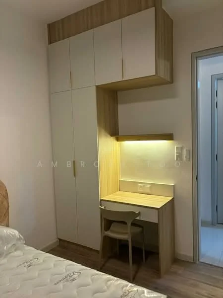 Bedroom features: built-in wardrobe with light wood finish, desk with integrated lighting, chair, laminate flooring, white walls, queen-size bed, bedside table, doorway leading to another room; style: modern.