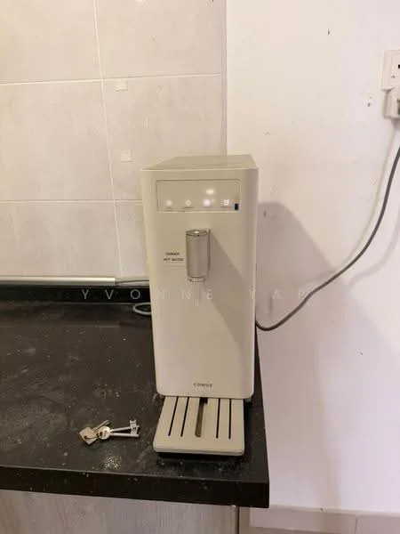 Room features: water dispenser, black countertop, grey tiled wall, key on countertop.