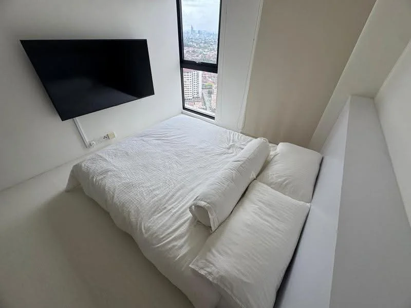 Bedroom features: queen-size bed with white bedding, wall-mounted TV, large window with city view, white painted walls, light-colored flooring, minimalist decor, bedside wall shelf; style: modern; view: city.