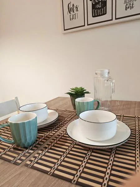Dining features: wooden dining table, woven placemats, ceramic plates, blue and white striped cups, glass water pitcher, small potted plant, framed wall art, neutral wall color; style: modern.