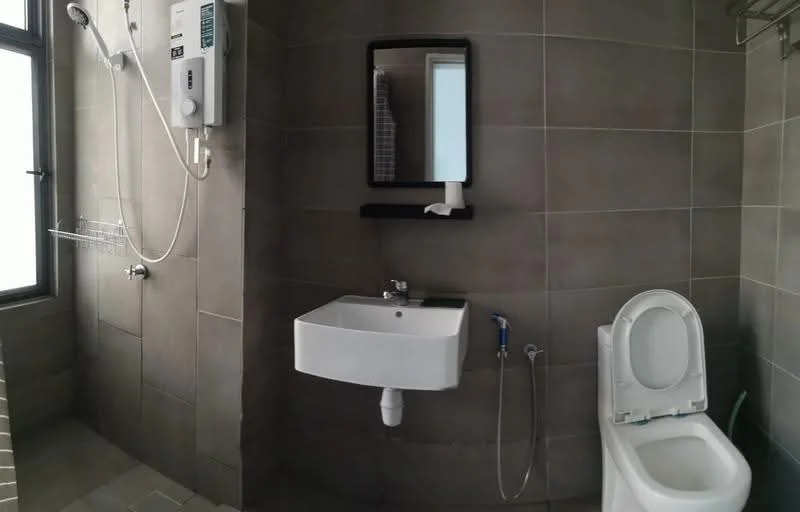 Bathroom features: grey tiled walls, grey tiled flooring, wall-mounted shower head, handheld shower, built-in shower shelf, white wall-mounted sink, mirror above sink, toilet, toilet paper holder, water heater, window for natural light; style: modern.