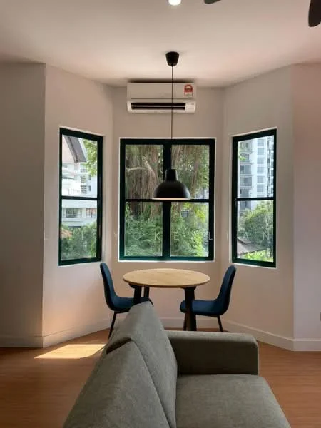 Living features: grey fabric sofa, round wooden dining table, 2 blue upholstered dining chairs, floor-to-ceiling windows, wall-mounted split AC, wooden flooring, pendant light, natural light from windows, decorative wall; style: modern; view: garden.