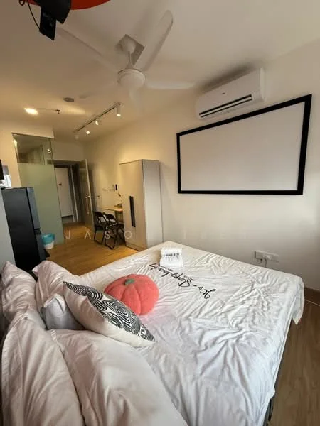 Bedroom features: queen-size bed with white bedding, decorative pillow, ceiling fan, wall-mounted air conditioning unit, wooden flooring, large wall-mounted screen, built-in wardrobe, desk with chair, light fixtures on ceiling, glass partition to bathroom, neutral painted walls; style: modern.