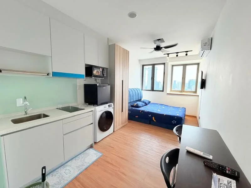 Kitchen features: white cabinetry, stainless-steel sink, single-bowl stainless-steel sink, built-in microwave, black fridge, ceramic cooktop, countertop with light blue backsplash, washing machine, wooden flooring; style: modern; view: city. Bedroom features: queen-size bed with blue bedding, ceiling fan, two windows, wooden flooring, wall-mounted air conditioning unit, study desk, black chair; style: modern; view: city.