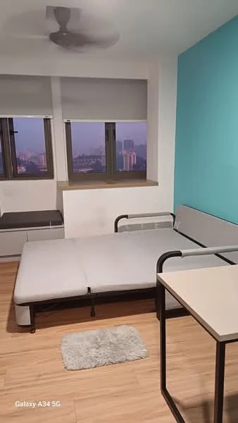 Bedroom features: light blue accent wall, white painted walls, laminate flooring, double bed frame without mattress, sofa bed, window with roller blinds, floor-to-ceiling windows, ceiling fan, small area rug, side table; style: modern; view: city.