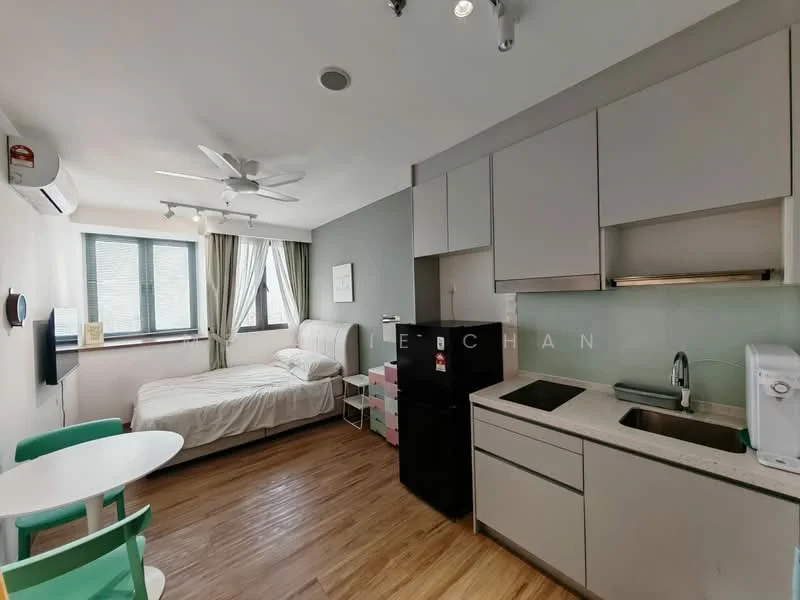 Living features: queen-size bed with white bedding, 2-blade ceiling fan, floor-to-ceiling windows, light grey painted walls, laminate flooring, kitchenette with grey cabinetry, stainless-steel sink, black fridge, microwave, white countertop, small dining table with green chairs, wall-mounted air conditioning unit; style: modern.