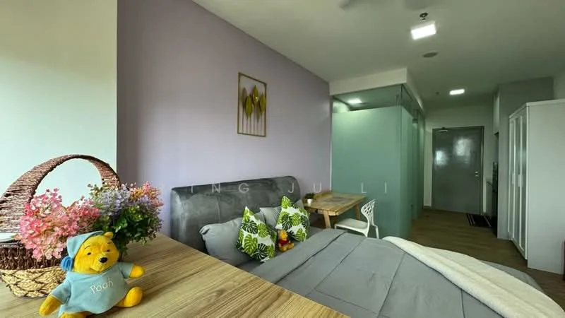 Bedroom features: queen-size bed with grey bedding, upholstered headboard, decorative throw pillows with floral pattern, wooden bedside table, white chair, wooden desk, wall-mounted mirror, light grey painted walls, laminate flooring, ceiling light fixture, window with sheer curtains, decorative wall art, basket with flowers; style: modern.