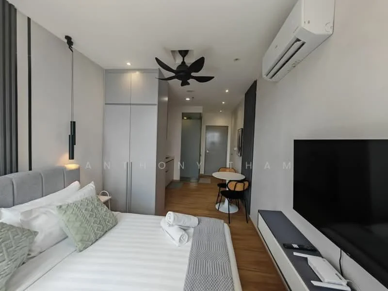 Bedroom features: king-size bed with grey upholstered headboard, white bedding with decorative pillows, 2 white towels rolled on the bed, wall-mounted TV, black TV console, 5-blade ceiling fan with light, wall-mounted air conditioning unit, wooden flooring, floor-to-ceiling windows with sheer curtains, built-in wardrobe with sliding doors, small round dining table with 2 chairs, decorative wall art; style: modern.