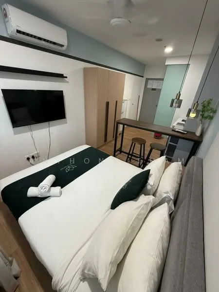 Bedroom features: queen-size bed, upholstered headboard, white bedding, 2 white towels, wall-mounted TV, 1 wall-mounted split AC, wooden flooring, study desk, 2 bar stools, kitchenette with white cabinetry, pendant lighting, neutral wall color, open closet, small indoor plant; style: modern.