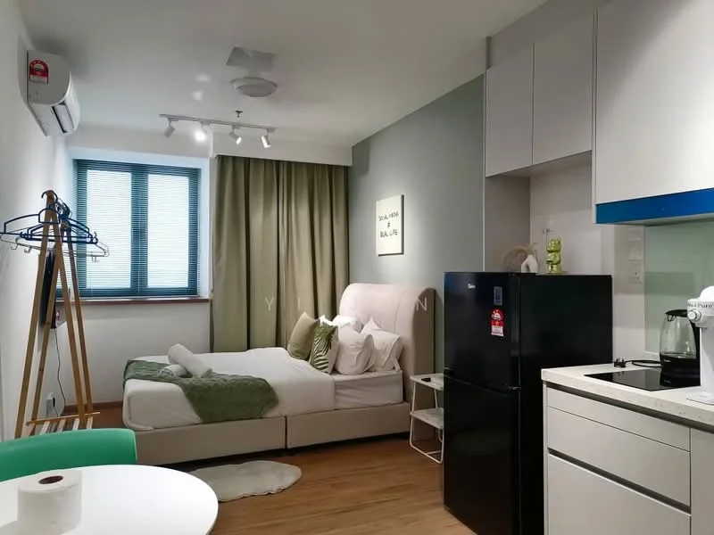 Room features: queen-size bed with upholstered headboard, green accent wall, white painted walls, wooden flooring, floor-to-ceiling window with blinds, curtains, refrigerator in black, built-in kitchen cabinetry in white, stainless-steel sink, countertop with white surface, kettle, coffee machine, clothes rack, dining table with green chair, track lighting, wall-mounted air conditioning unit; style: modern.