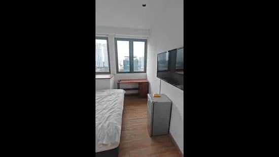 Bedroom features: queen-size bed with white bedding, wooden flooring, white painted walls, floor-to-ceiling windows, city view, wall-mounted TV, wooden desk, grey storage cabinet; style: modern; view: city.