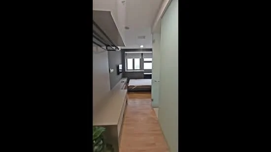 Room features: wooden flooring, light grey painted walls, large windows with blinds, built-in wardrobe, open shelving, minimalist design, neutral color palette, recessed ceiling lights; style: modern.