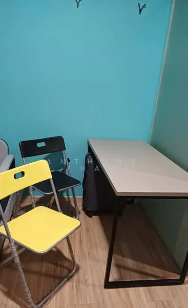 Room features: turquoise painted walls, wood laminate flooring, small rectangular table, black folding chair, yellow folding chair, coat hooks on wall; style: modern.