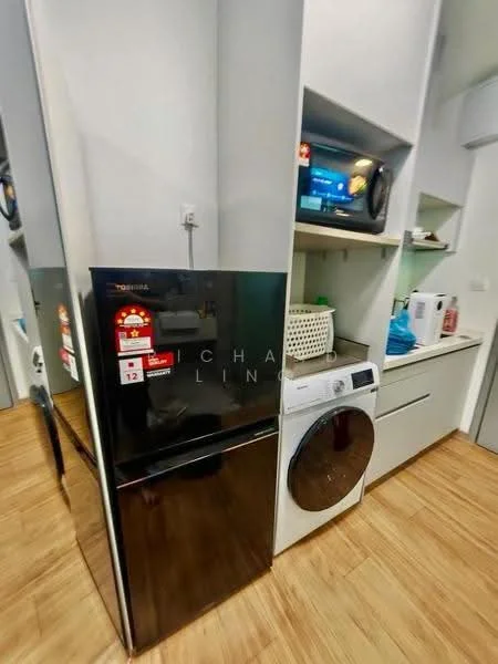Laundry features: black refrigerator, front-load washing machine, white cabinetry, wooden flooring, countertop, microwave, basket for storage, blue towels; style: modern.