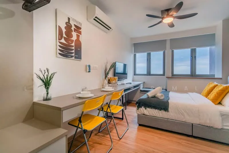 Room features: queen-size bed with white bedding, upholstered headboard, 2 yellow dining chairs, wooden dining table, wall-mounted TV, desk with storage drawers, 5-blade ceiling fan, wall-mounted air conditioning unit, large windows with roller blinds, wood laminate flooring, decorative wall art, plant in ceramic pot; style: modern; view: city.