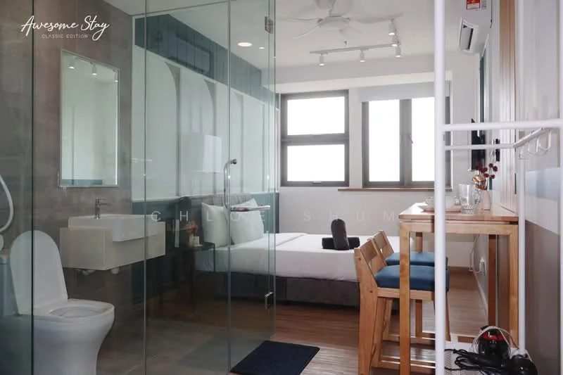 Room features: glass shower enclosure, white toilet, floating sink with wall-mounted faucet, wooden flooring, queen-size bed with white bedding, two large windows with city view, wooden dining table with two chairs, recessed ceiling lights, wall-mounted mirror, decorative wall paneling; style: modern; view: city.