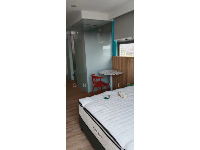 Bedroom features: queen-size bed with white bedding, wooden flooring, large window with city view, glass partition wall, round table with patterned top, red chair, wall-mounted light fixture, built-in wardrobe, decorative wall paneling; style: modern; view: city.