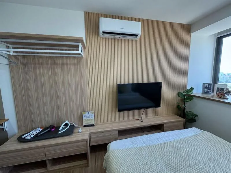 Bedroom features: wooden flooring, feature wall with vertical wood paneling, wall-mounted TV, 1 wall-mounted split AC, built-in wardrobe with open shelving, wooden console table, houseplant in ceramic pot, bed with white bedding; style: modern; view: city.