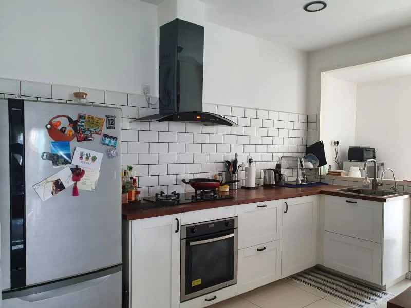 Kitchen features: stainless-steel fridge, built-in oven, 4-burner gas hob, black range hood, white shaker cabinets, wood countertop, white subway tile backsplash, double-bowl stainless-steel sink, kitchen utensils, wall-mounted shelf, decorative magnets on fridge, floor tiles, recessed downlights; style: modern.