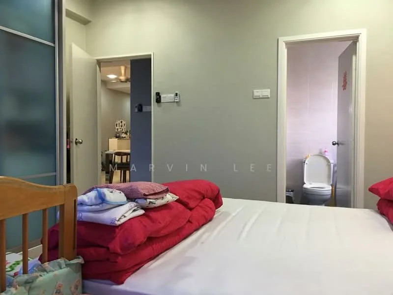 Bedroom features: double bed with red bedding, wooden bed frame, light grey painted walls, white ceiling, carpeted flooring, nightstand, doorway leading to bathroom, doorway leading to hallway, stack of pillows on bed. Bathroom features: toilet, light-colored wall tiles, doorway leading to bedroom.