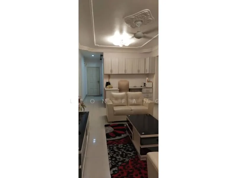 Living features: cream painted walls, white ceiling with crown moulding, 5-blade ceiling fan with light, white tiled flooring, 3-seater leather sofa in cream, coffee table with black glass top, area rug with geometric pattern in red and black, TV console, wall-mounted TV; style: modern. Room features: white cabinetry, kitchenette with countertop, door leading to hallway.