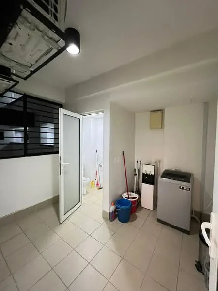 Laundry features: tiled flooring, white painted walls, ceiling light fixture, washing machine, sink, cleaning supplies, broom, bucket, door to bathroom, window, shelving unit.