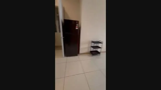 Room features: white painted walls, ceramic tile flooring, dark wood fridge, metal shelving unit.