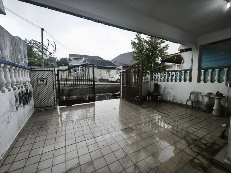 Exterior features: paved flooring, metal gate, fence with decorative balustrade, covered area, outdoor seating, drainage system, surrounding greenery.