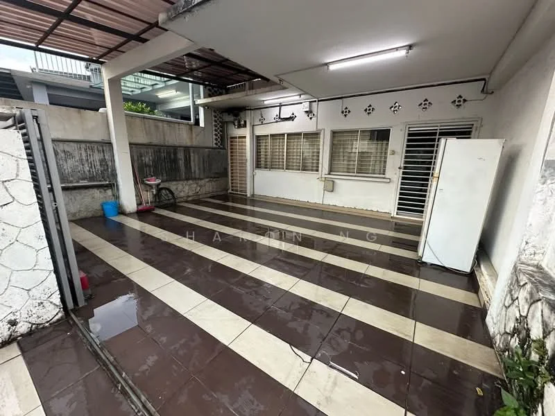 Exterior features: paved flooring with alternating dark and light tiles, white walls, metal grilles on windows, sliding door, outdoor space covered by roof, exposed concrete wall, freestanding white fridge, water tap, drainage system visible; style: modern.