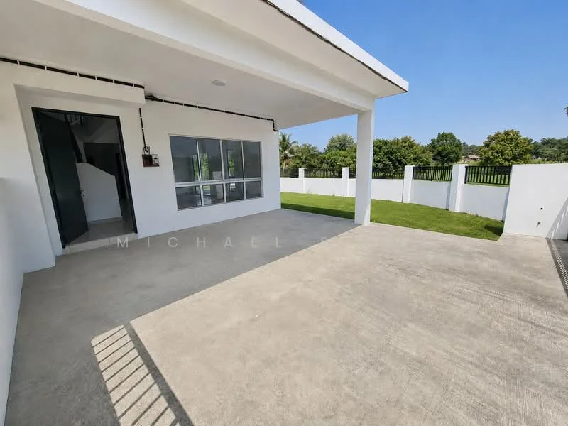 Exterior type: detached bungalow; features: white painted facade, flat roof, single-storey, manicured lawn, concrete patio, fenced yard, large windows, door leading to interior, surrounded by greenery; style: modern.