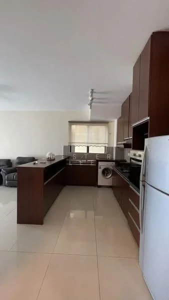 Kitchen features: brown wooden cabinetry, stainless-steel refrigerator, built-in oven, freestanding range oven, double-bowl stainless-steel sink, chrome pull-down faucet, white quartz countertop, tile flooring, recessed downlights, washing machine, open layout to living area, window with blinds; style: modern.