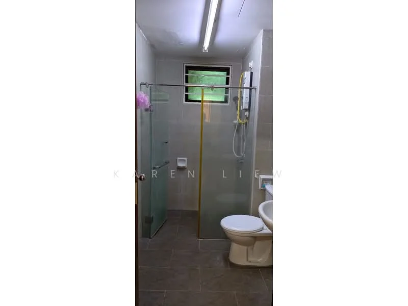 Bathroom features: glass shower enclosure, gold trim on shower door, rain shower head, handheld shower, white toilet, wall-mounted toilet paper holder, grey tiled walls, dark grey floor tiles, small window for natural light, chrome shower controls, built-in shower shelf; style: modern.