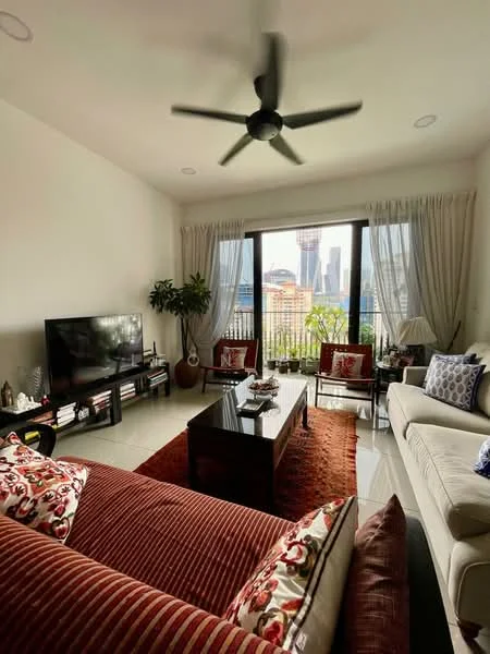 Living features: 3-seater fabric sofa in cream, 2-seater fabric sofa in burgundy, coffee table in dark wood, TV console in dark wood, wall-mounted TV, area rug with geometric pattern in orange, 5-blade ceiling fan with light, floor-to-ceiling windows, sheer curtains, decorative cushions, houseplants in ceramic pots, framed artwork on walls; style: modern; view: city.