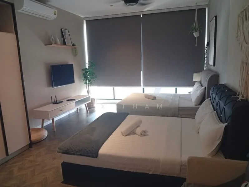 Bedroom features: two queen-size beds with upholstered headboards, white bedding with grey throw blanket, wall-mounted TV on white console, light grey walls, dark grey roller blinds, ceiling fan, laminate flooring, decorative plant on shelf, open shelving unit, side table with lamp; style: modern.